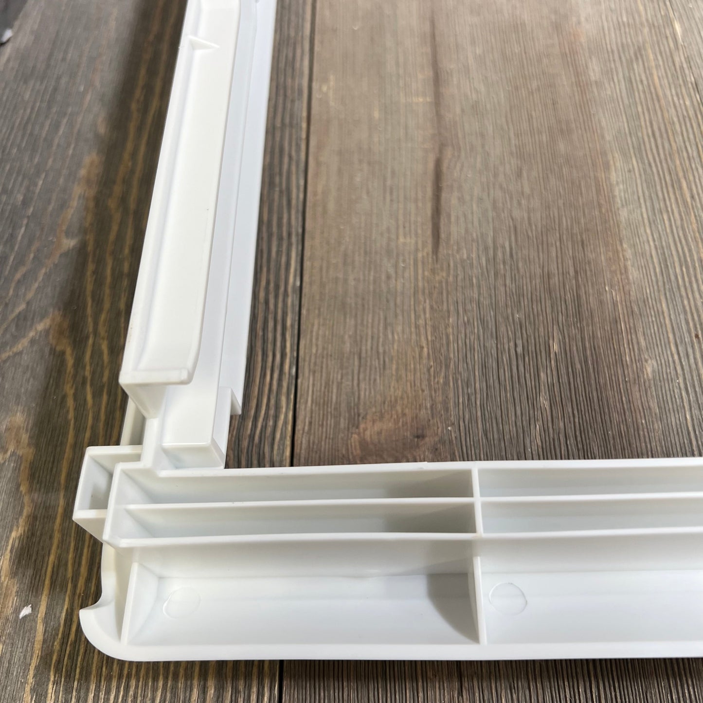 White refrigerator crisper drawer cover frame with detailed corner view, compatible with Frigidaire models.