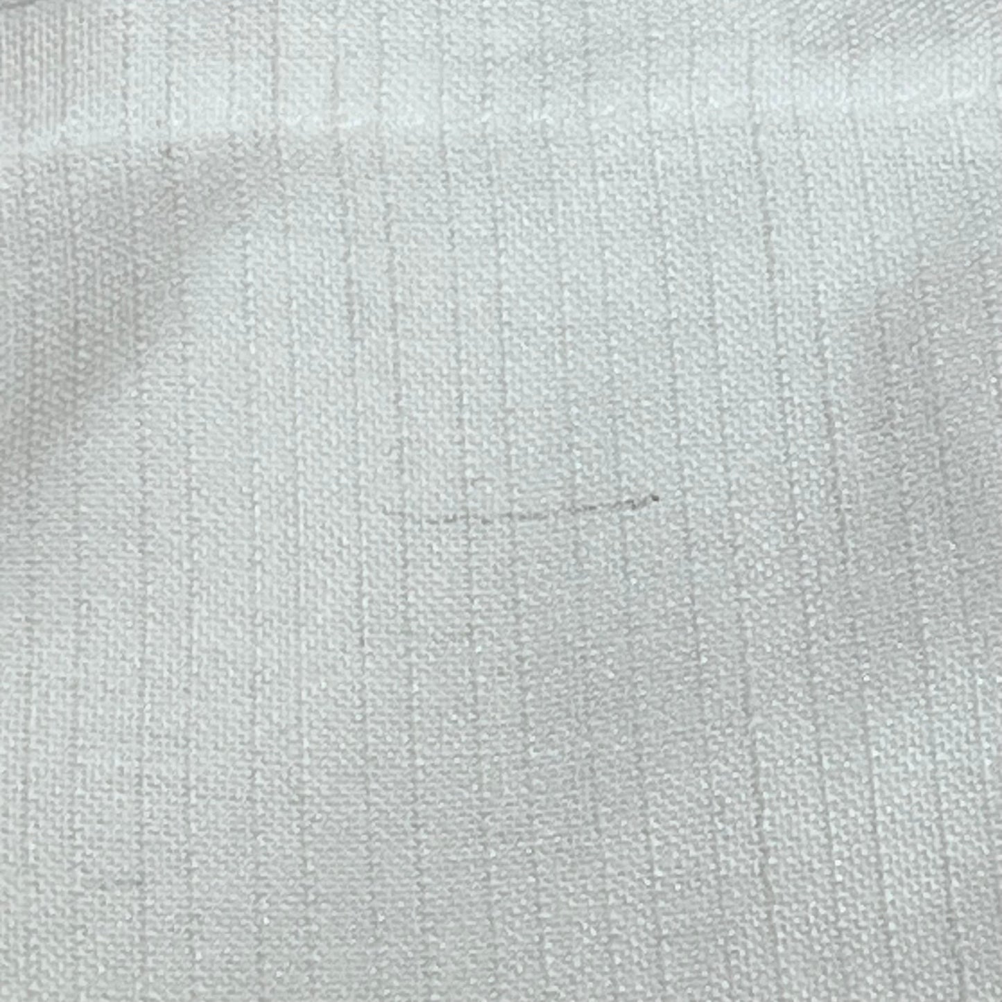 Close-up of white linen blend curtain fabric texture, showcasing light filtering and lightweight quality for farmhouse decor.
