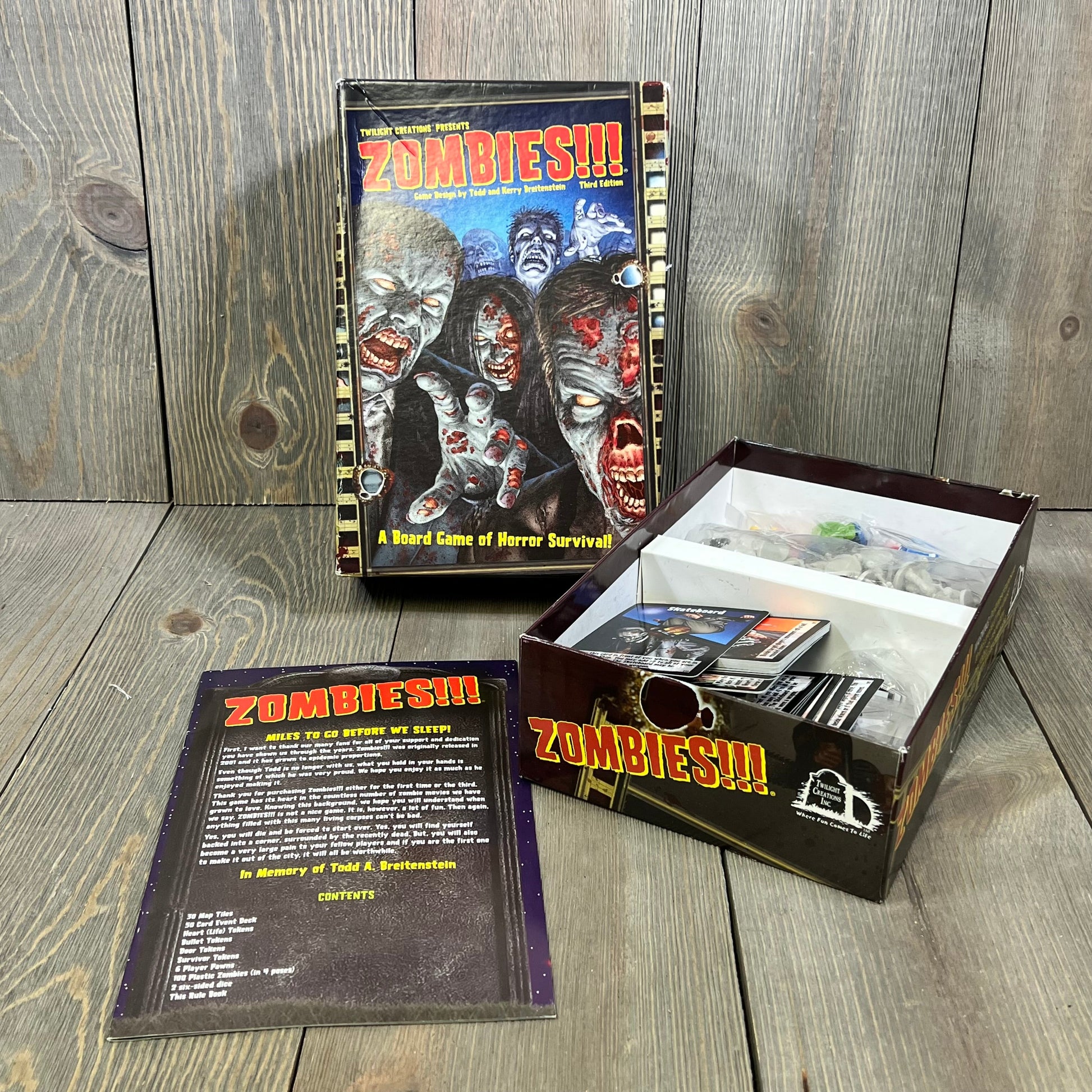 Zombie Survival Board Game Third Edition box with open contents, featuring cards and pieces for 2-6 players, ages 15+.