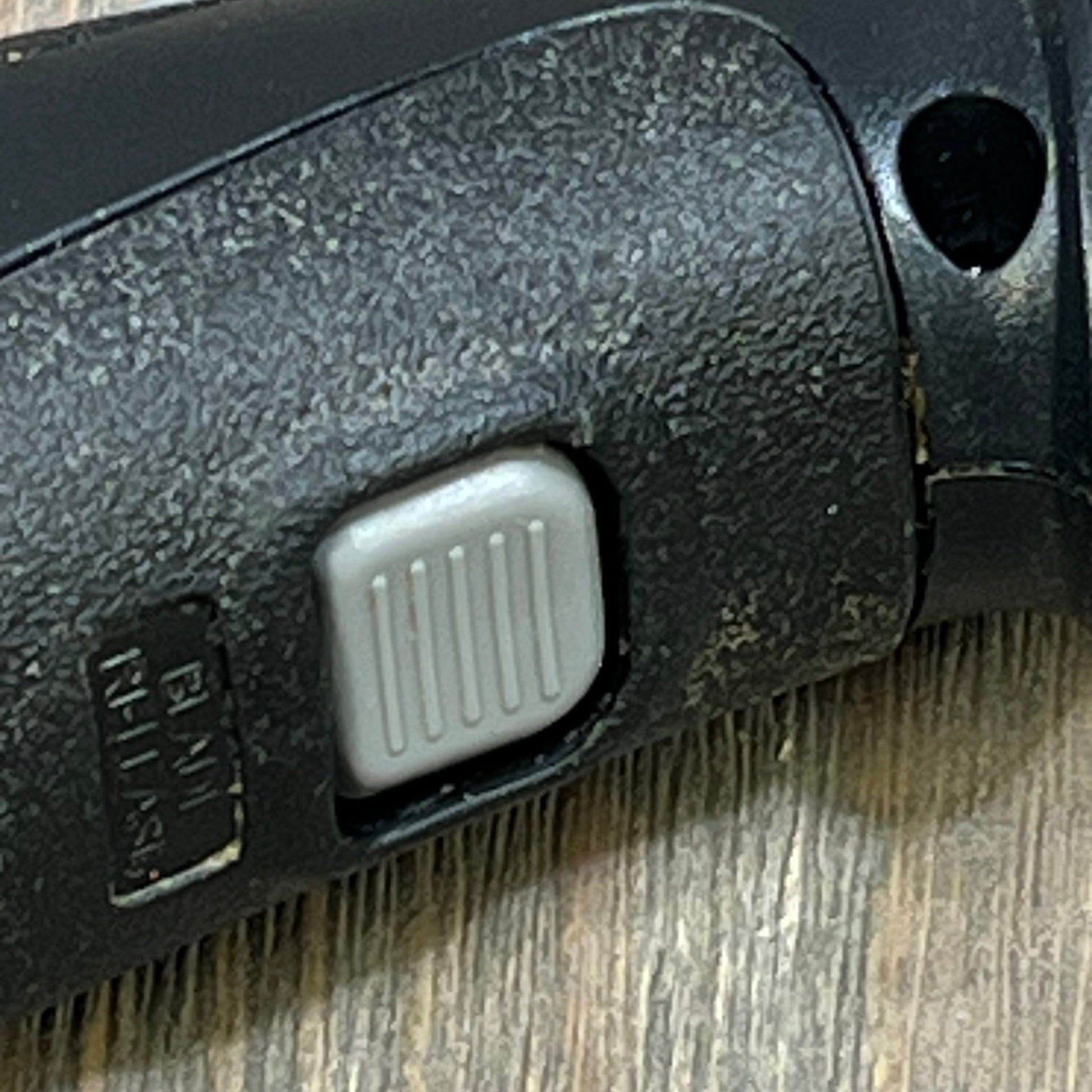 Close-up of electric knife handle with gray button