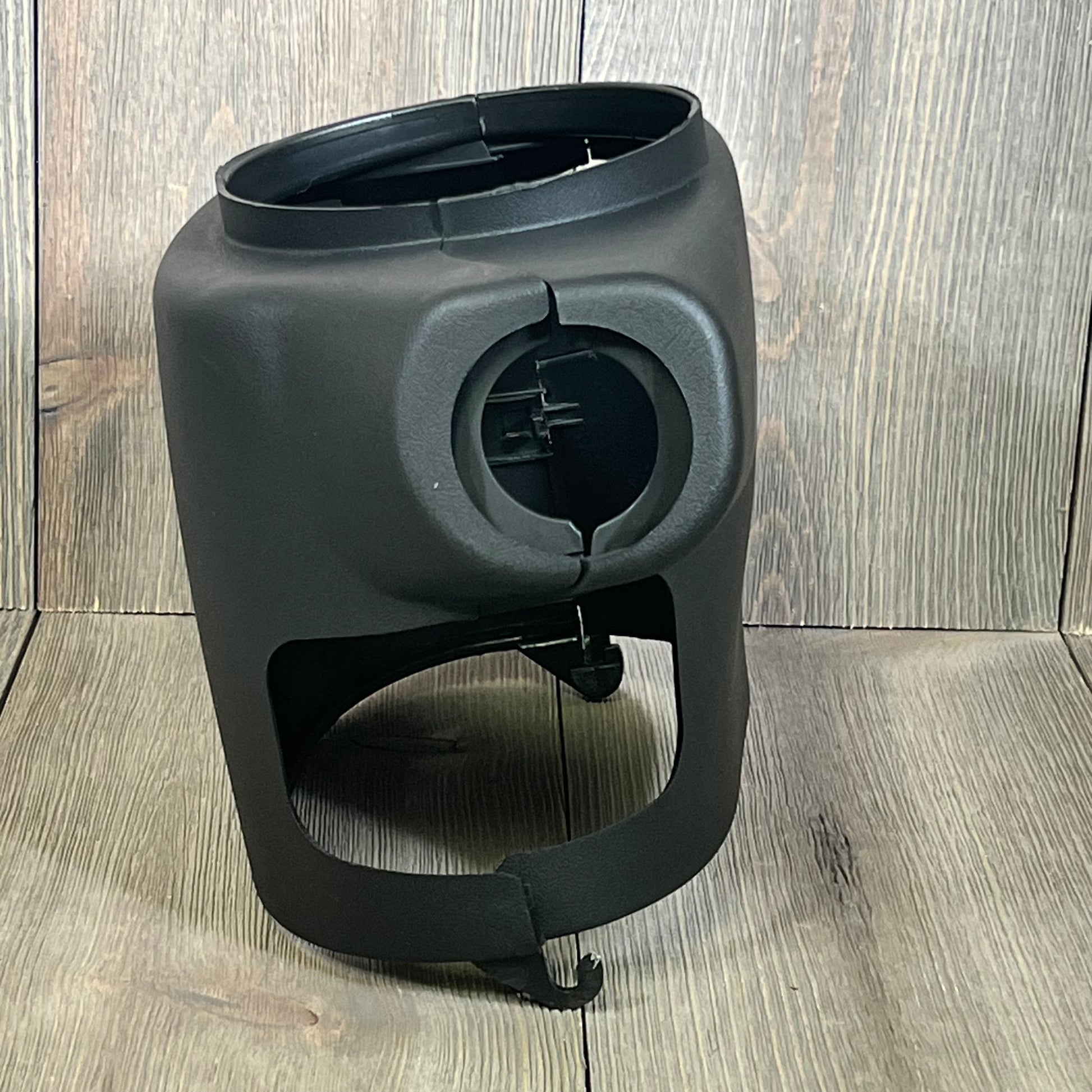 Black LOSTAR steering column cover shroud for 2003-2006 Chevy/GMC, shown on wooden background. Durable and precise fit.
