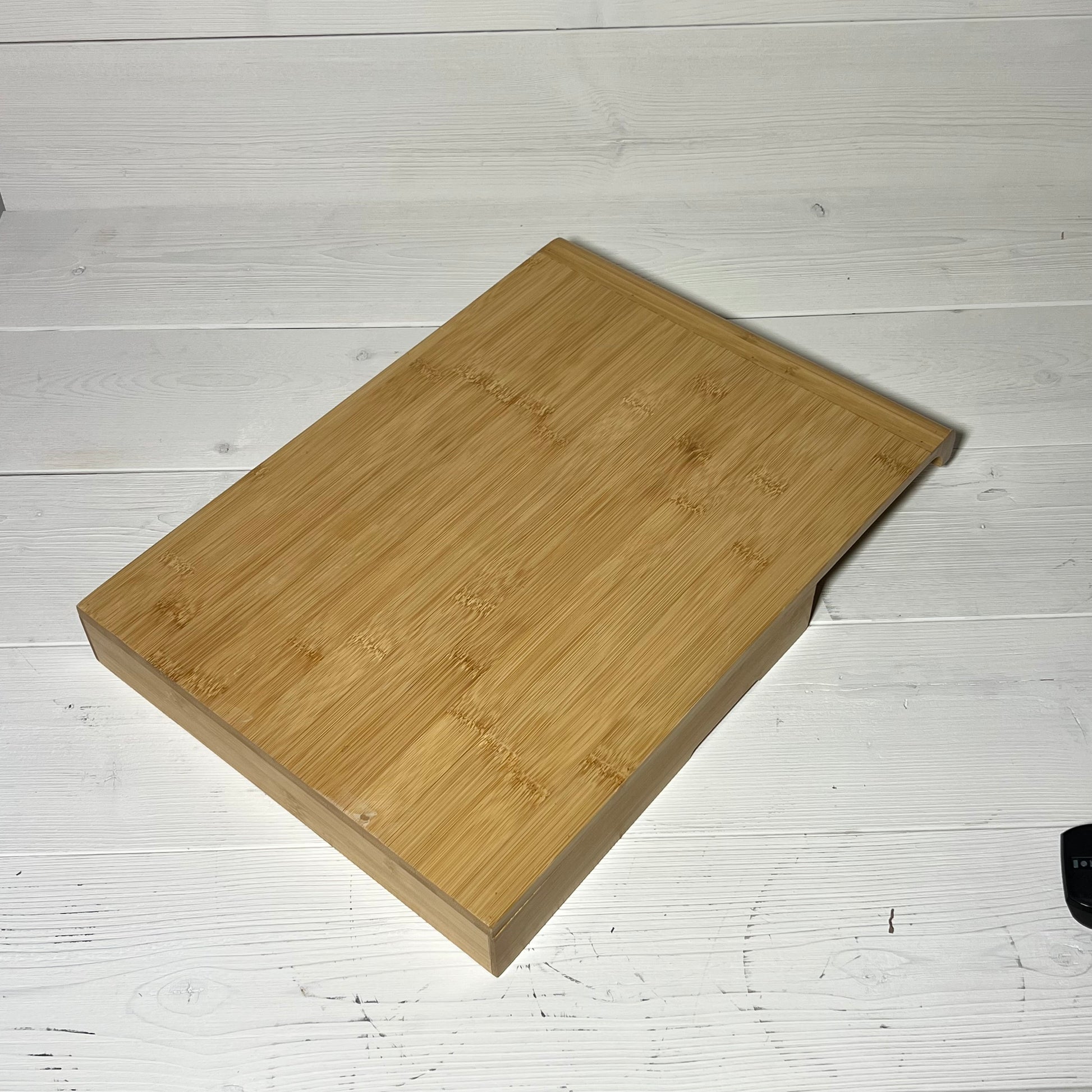 Bamboo in-drawer knife block organizer on a white wooden surface.