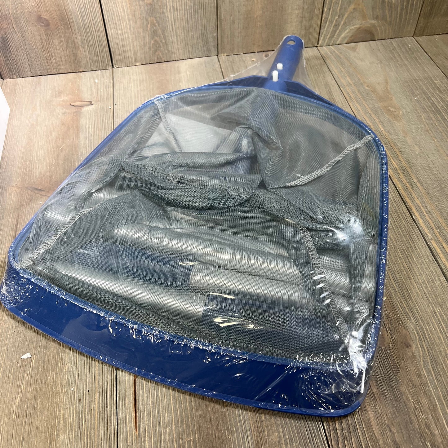 "Poolaza 3-in-1 Pool Cleaning Kit skimmer net wrapped in plastic on a wooden surface."
