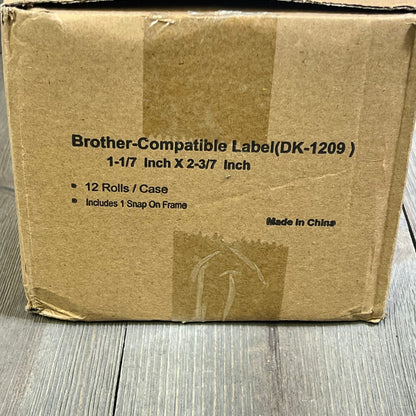 Brown shipping box displaying Brother DK-1209 compatible label specifications, includes 12 rolls and 1 snap-on frame.
