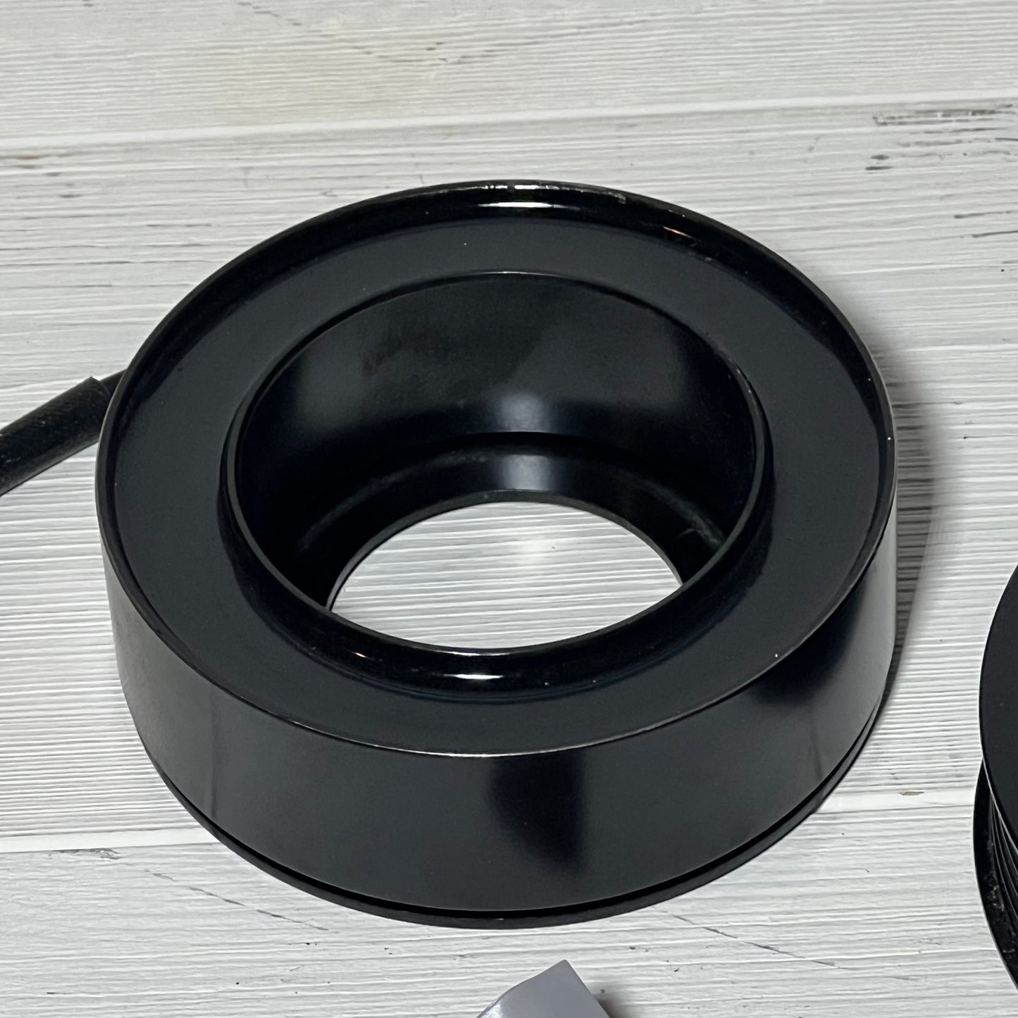AC Compressor Clutch component from uxcell for Mazda 3, 2010-2013, shown on a light wooden surface.
