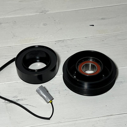 AC Compressor Clutch Set for Mazda 3 2010-2013 with repair components on a wooden surface.