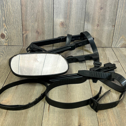 Universal clip-on towing mirror with extenders for pickups and RVs, laid on wooden surface, showcasing adjustable straps.