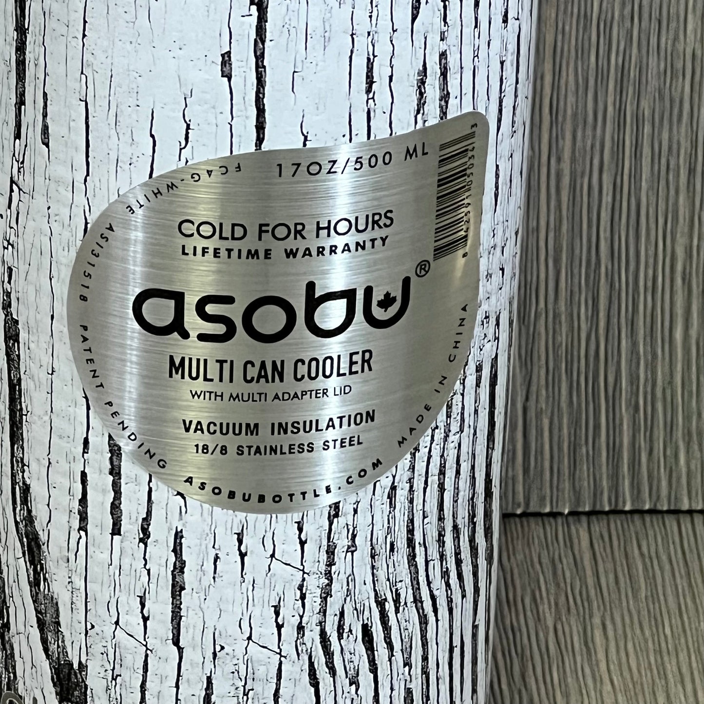 White Asobu Multi Can Cooler with wood grain texture, vacuum insulated for 12 oz and 16 oz drinks, and stainless steel label.