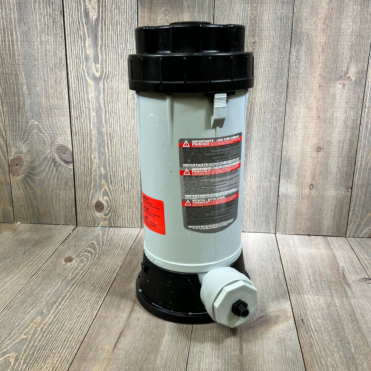 Automatic chlorinator feeder with black lid and safety labels for swimming pools and ponds.