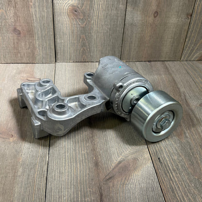 Toyota Lexus drive belt tensioner assembly for 3.5L 4.0L V6 engines, part number 16620-31040, on wooden surface.