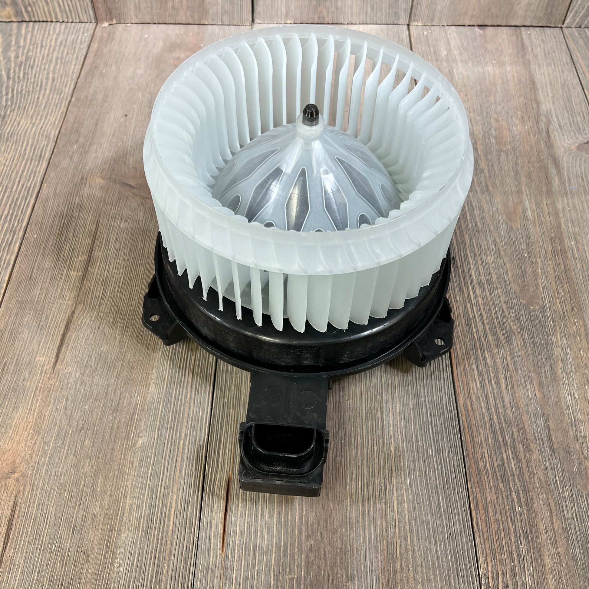 AC blower motor with fan assembly for Honda Accord 2013-2017, shown on a wooden surface. Ideal for HVAC replacement.