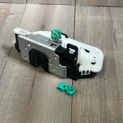 Rear passenger side door lock actuator latch for Ford F150 2009-14, with green clips, on wooden surface.