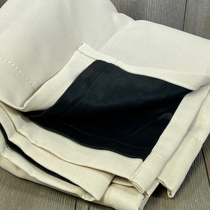 Champagne blackout curtains with black liner, folded to show thermal insulation and soundproof features.