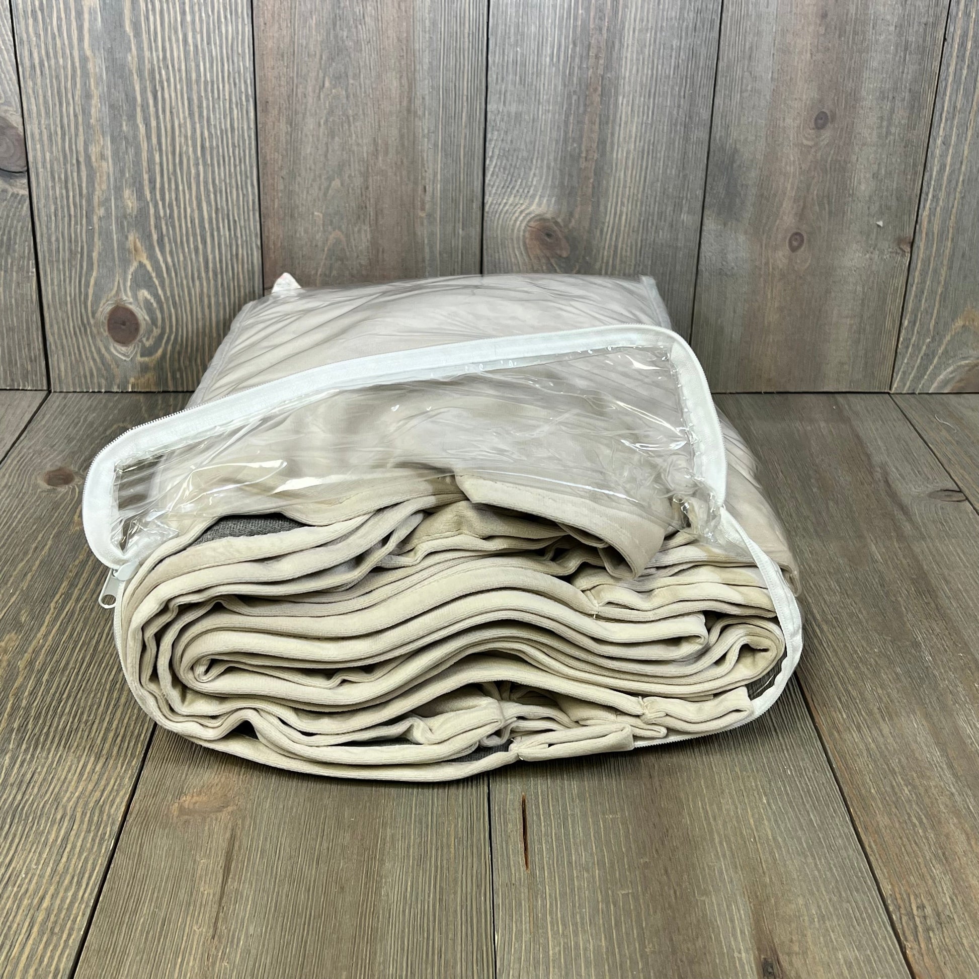 Beige velvet curtains folded in clear packaging, showcasing luxury blackout design for bedroom or living room.