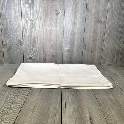 Neutral tan lumbar pillow cover with embroidered leaf design and piping, perfect for coastal patio or indoor use.