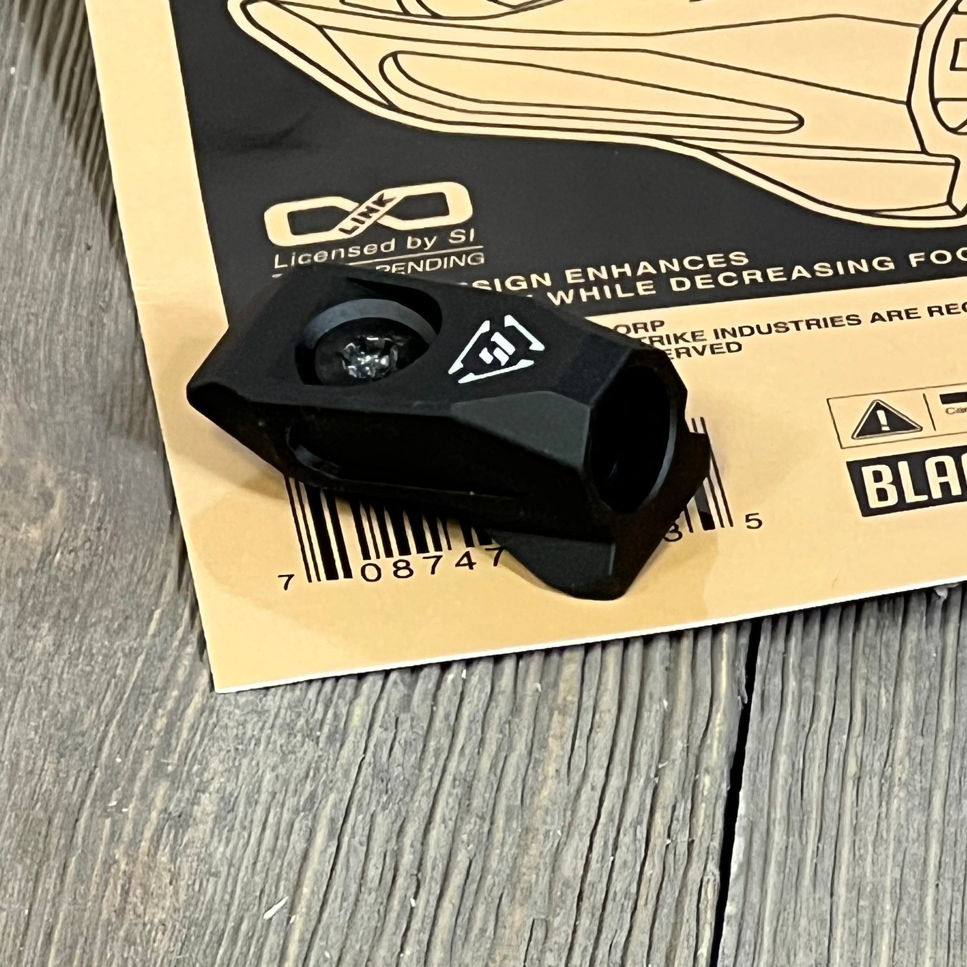 Black Strike Link Angled QD Mount on wooden surface, showcasing durable design and compact size.