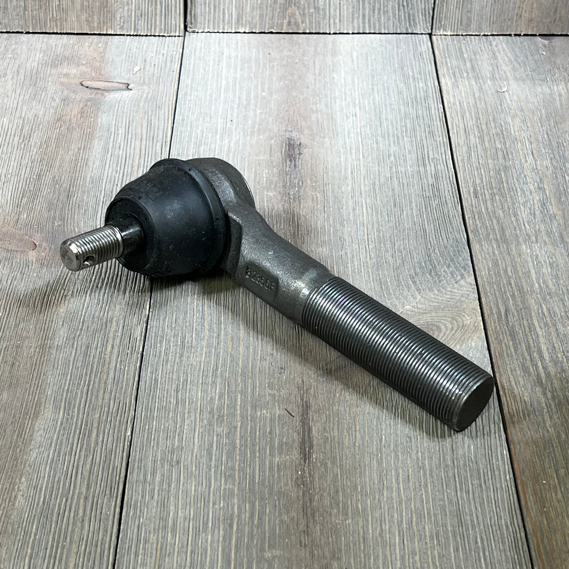 Durable MOOG ES3625 steering tie rod end for Dodge Ram 2500, showcasing robust metal construction on wood surface.