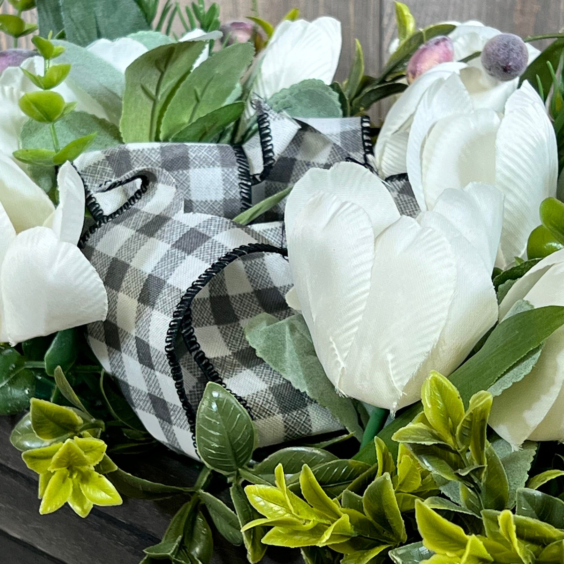 Artificial white tulips with greenery and checkered ribbon in a wood box, perfect for spring table decor.