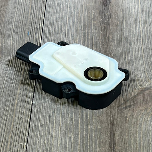 Air actuator motor for Nissan Rogue 2017-2020, featuring a robust black and white design on a wooden surface.