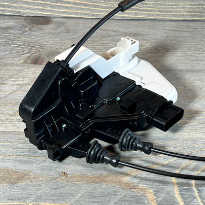 Black and white Power Door Lock Actuator for Hyundai Santa Fe, Front Right Passenger Side, on a wooden surface.