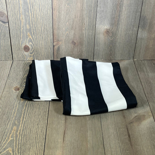 Black and white striped throw pillowcases, folded on a wooden surface, made of durable cotton polyester.