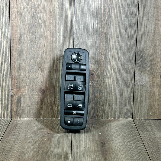 Master Power Window Switch for Chrysler 300, 200, Dodge Charger, Ram 1500-3500 on wood background.