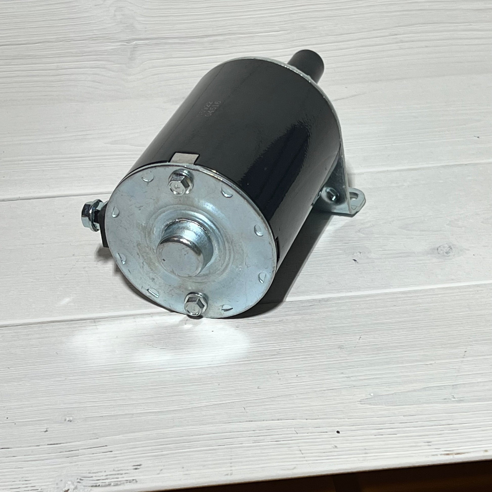 Starter motor for Kawasaki engines FH381V-FH770D, compatible with John Deere X300-X304, shown on light wood surface.