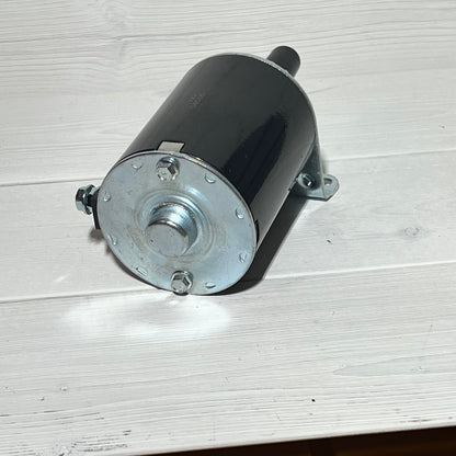 Starter motor for Kawasaki engines FH381V-FH770D, compatible with John Deere X300-X304, shown on light wood surface.