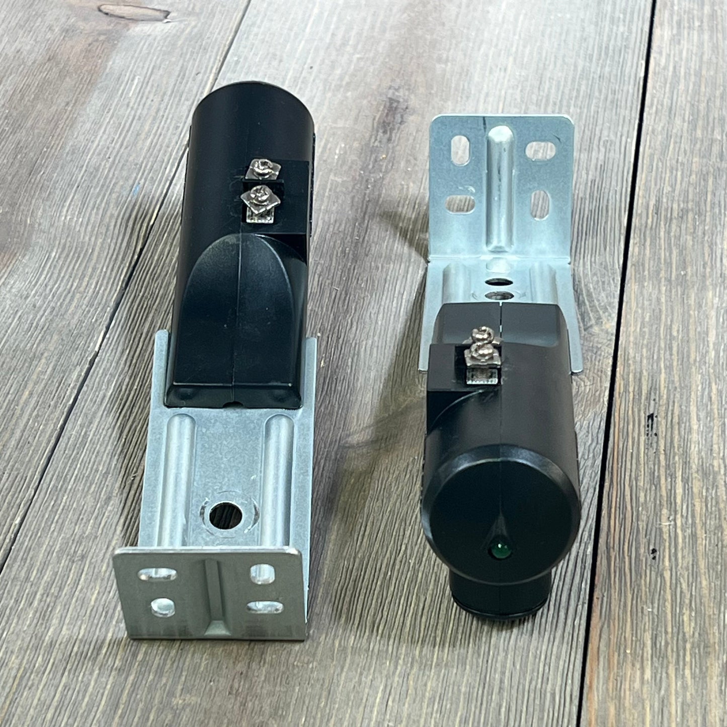 Genie Safe-T-Beam Replacement Kit with sender and receiver on a wooden surface, showcasing durable black casing.