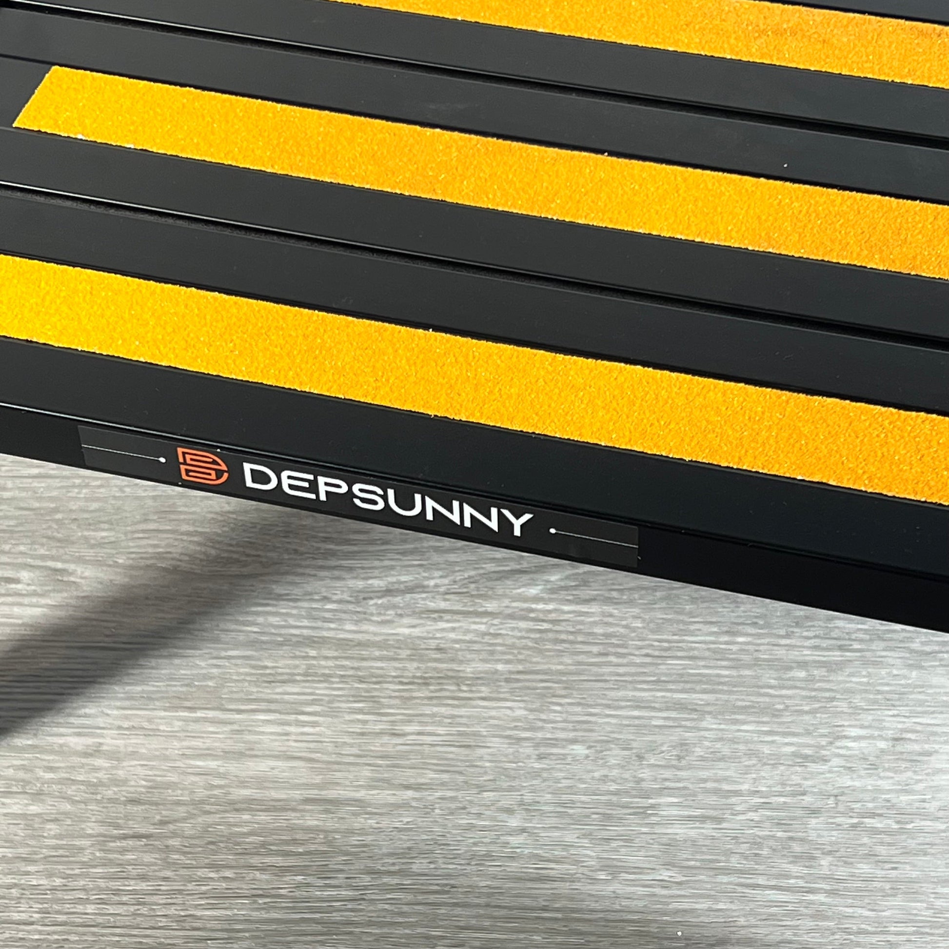 Black DEPSUNNY RV step with bright yellow non-slip strips on aluminum platform.