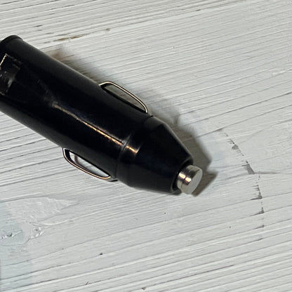 Black car adapter plug for Resmed AirSense 11, compatible with AirMini, on a wooden surface. Ideal for CPAP machine power.