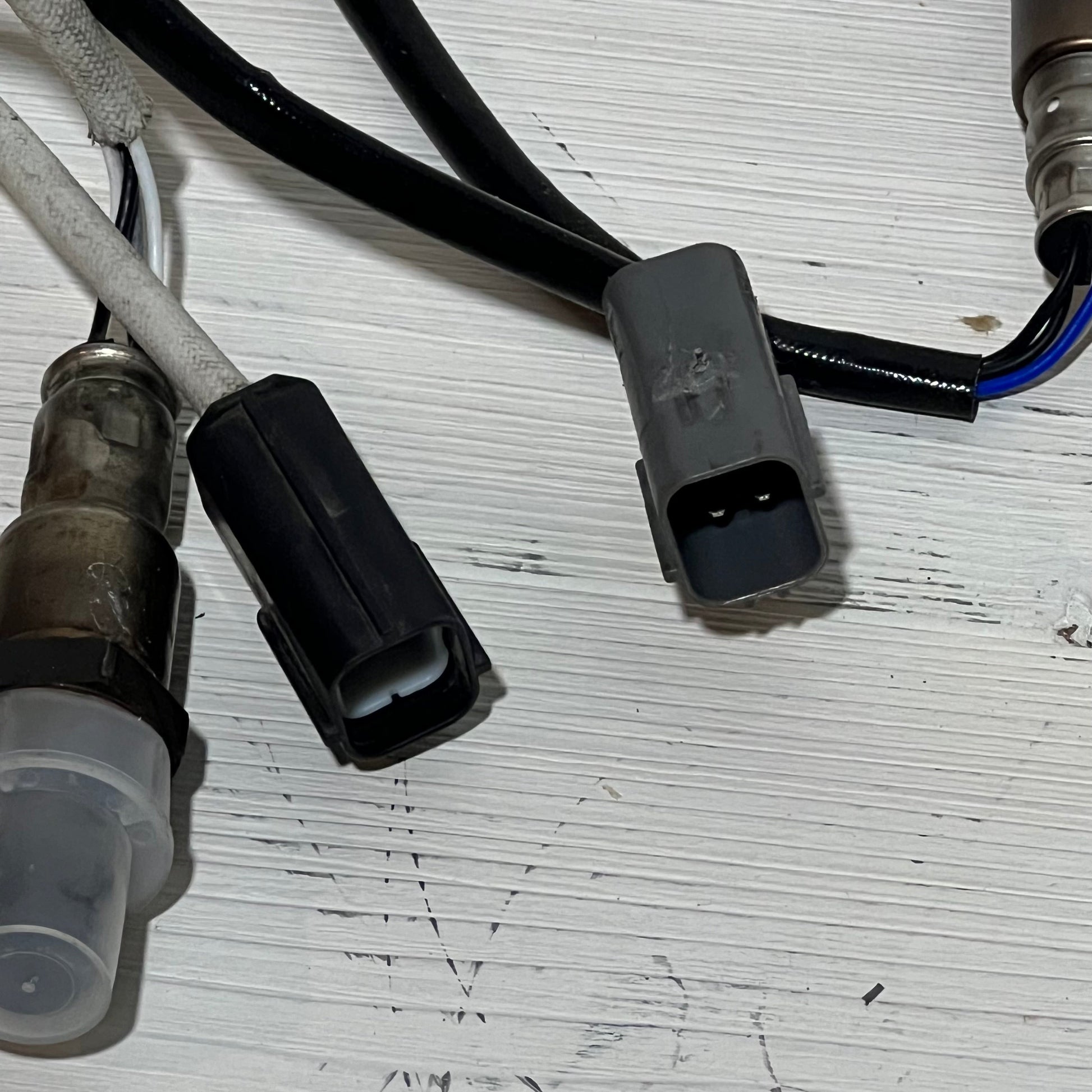 Close-up of Nissan Rogue 2.5L upstream and downstream oxygen sensor connectors on a white background.