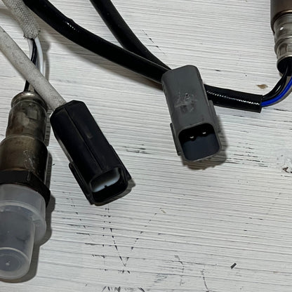 Close-up of Nissan Rogue 2.5L upstream and downstream oxygen sensor connectors on a white background.