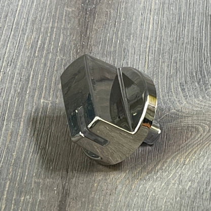 Chrome burner control dial knob replacement for LG gas stove, part AEZ73293801, shown on a wooden surface.