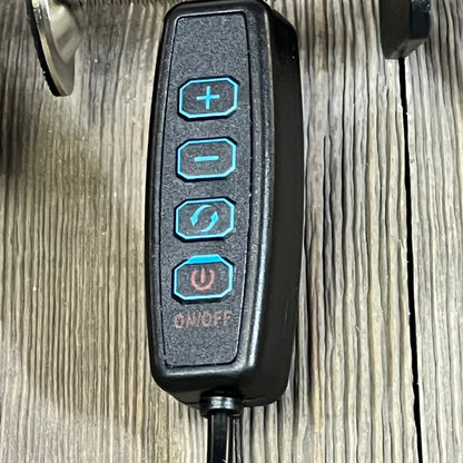 LED desk lamp remote control with brightness and mode buttons on wooden surface.