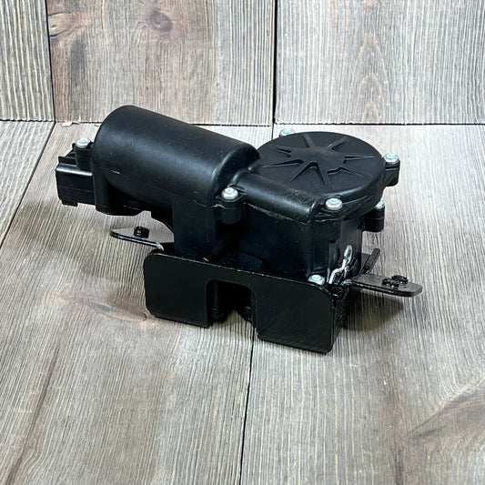 Black Nakkaa 931-107 rear hatch tailgate lock actuator for 2007-2014 SUVs, shown on a wooden background.