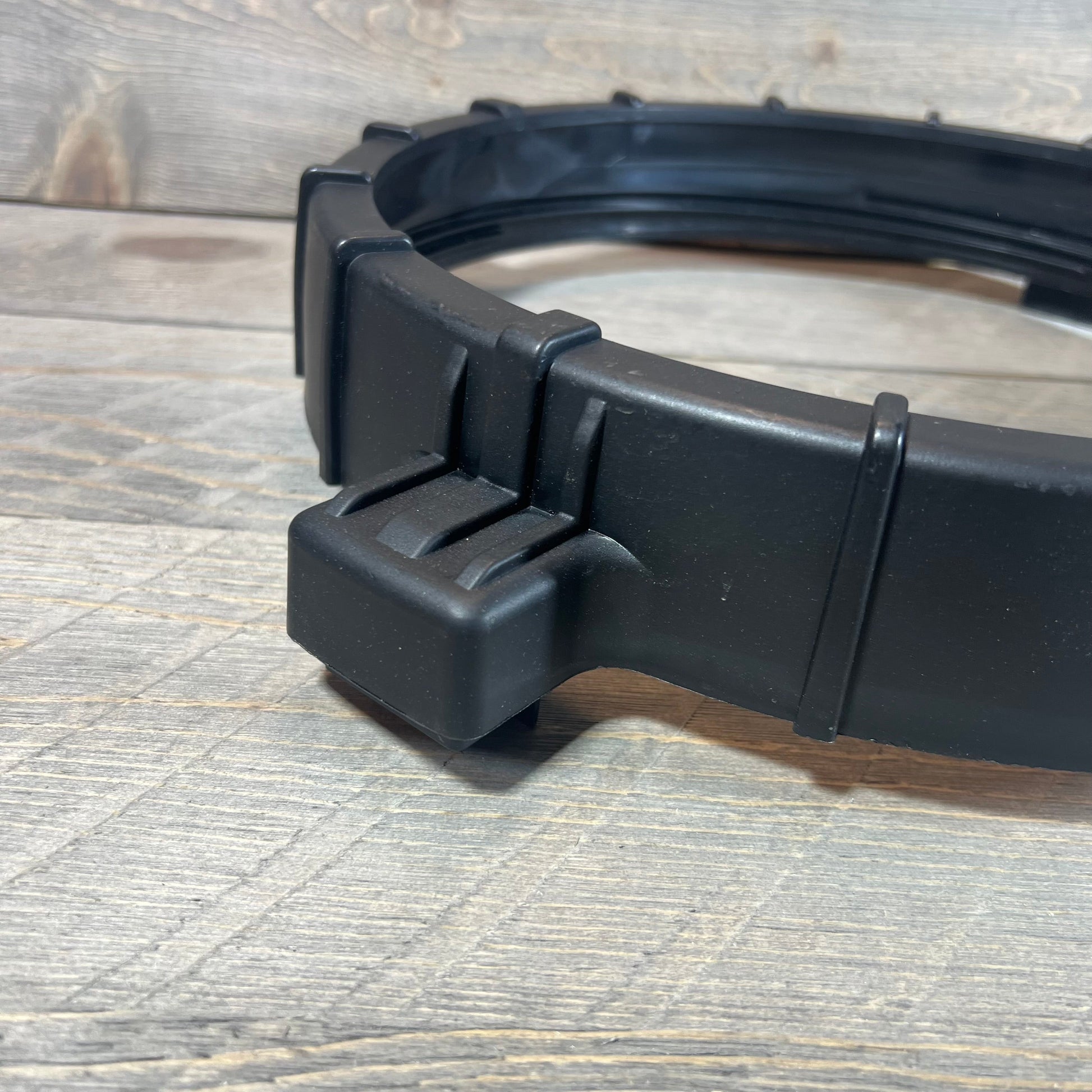 Black locking ring assembly for Pentair Clean & Clear Predator filter, detailed view on rustic wood background.