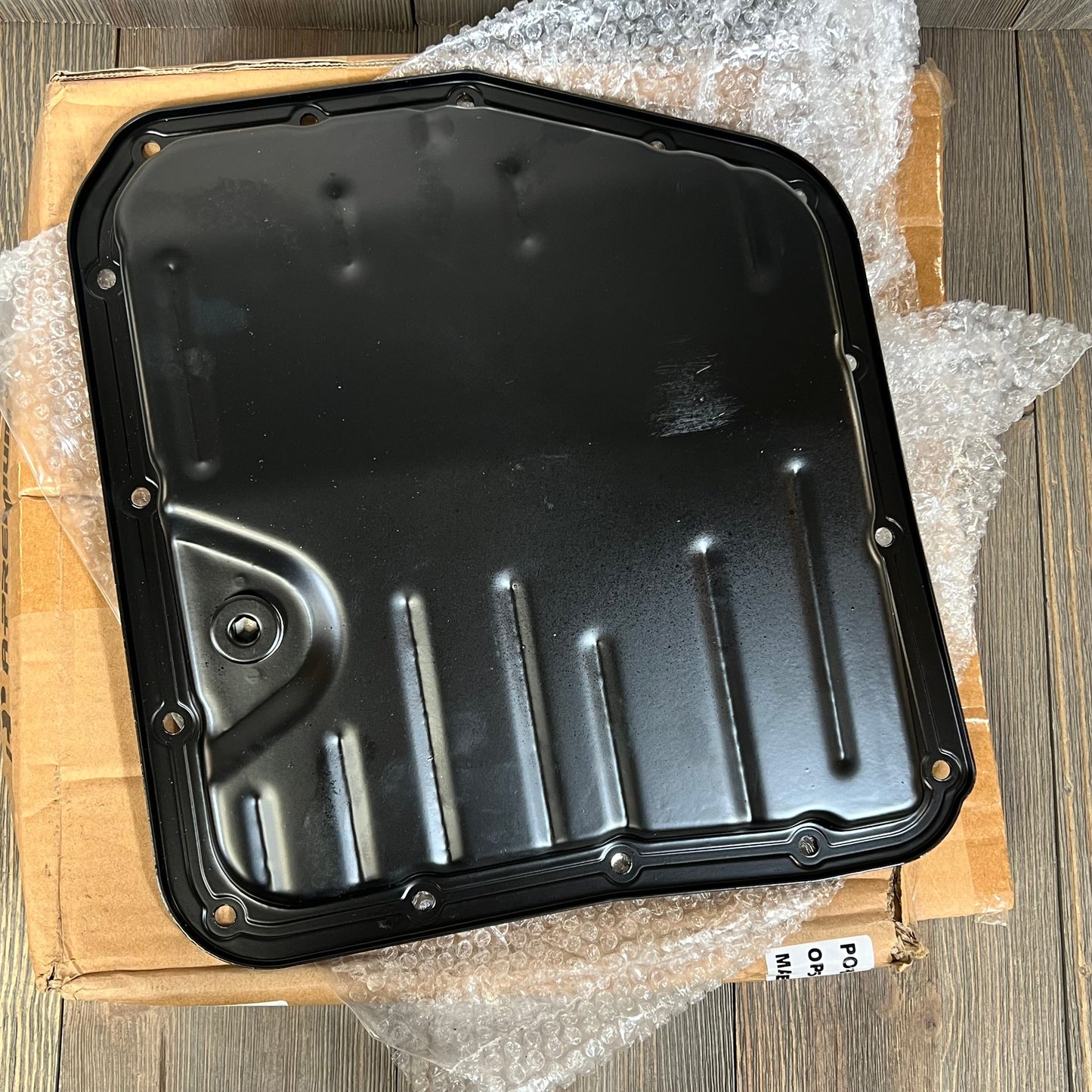 Premium black transmission oil pan with drain plug for Toyota Camry and Corolla, featuring durable 15 bolt holes.