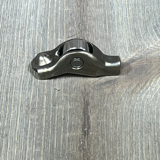 Ford 3L3Z-6564-BA Rocker Arm Valve Assembly on wooden surface, showcasing durable metal construction.