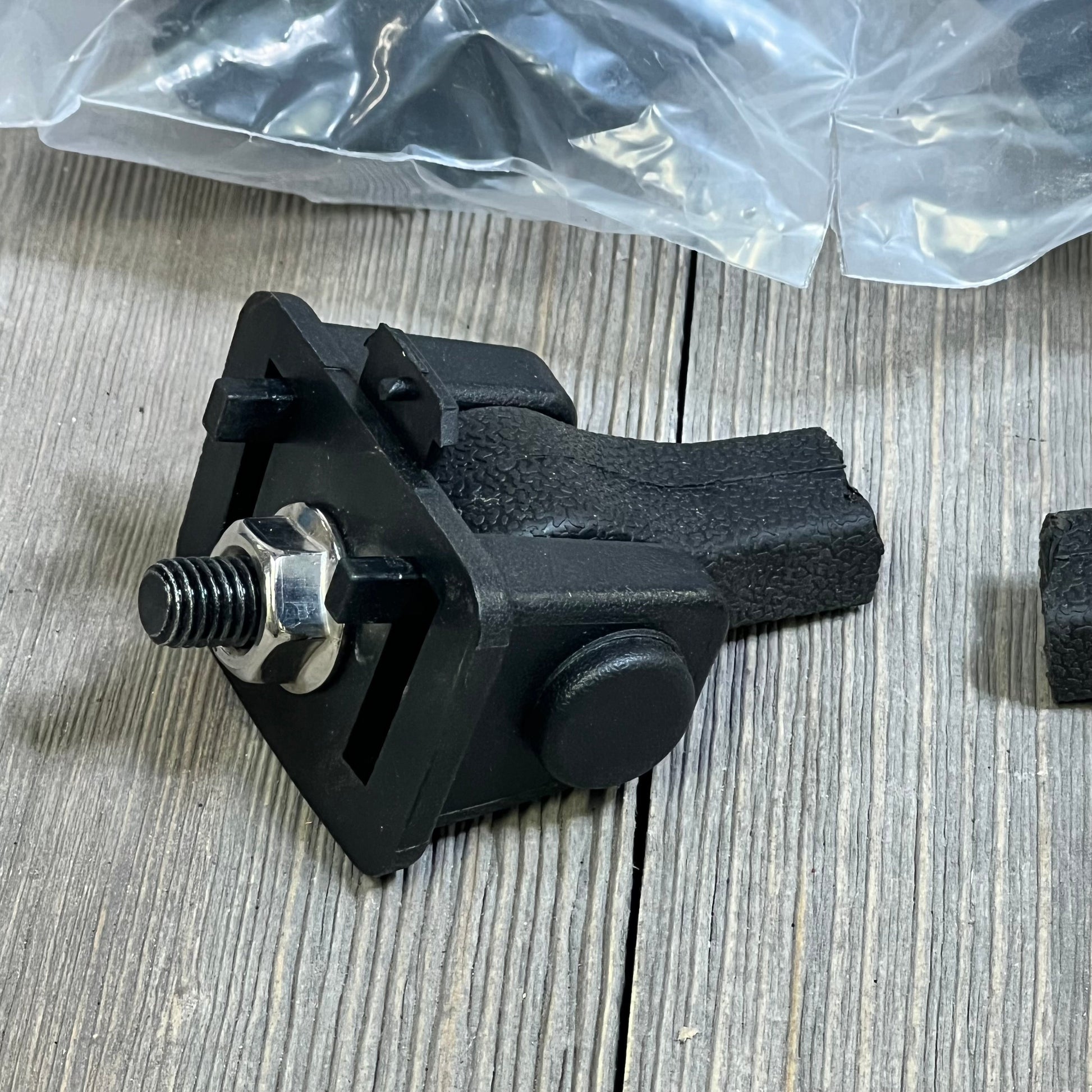 Black Jeep TJ hood latch with textured grip, factory style catch kit part for 1997-2006 Wrangler on wood surface.
