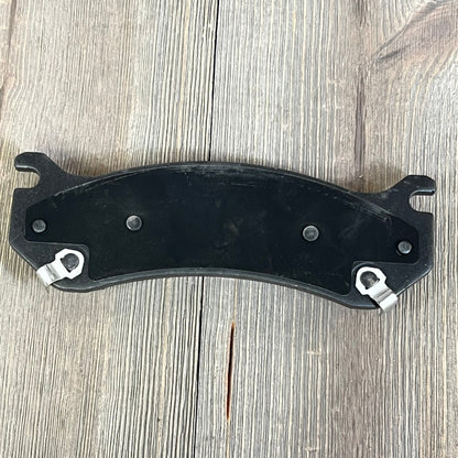 Ceramic rear brake pad for Chevrolet Suburban 2500, enhancing performance and durability on wooden background.