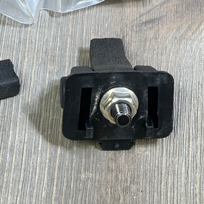 Black Jeep TJ hood latch component on wooden surface, showcasing sturdy design for 1997-2006 Wrangler models.