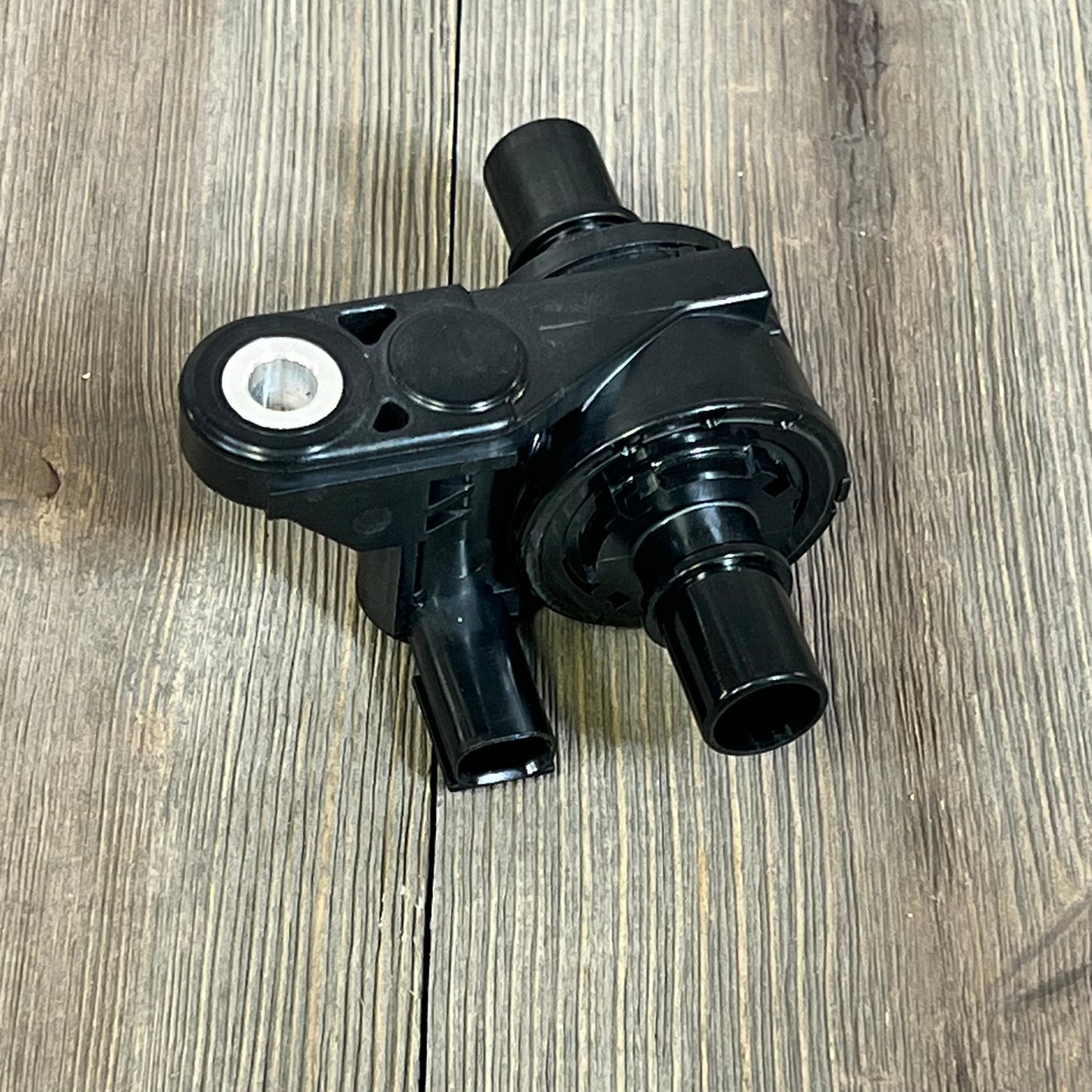 Black NOVAPARTS coolant water control valve for 2019-2023 Toyota Corolla and Lexus UX200 models, on wooden surface.