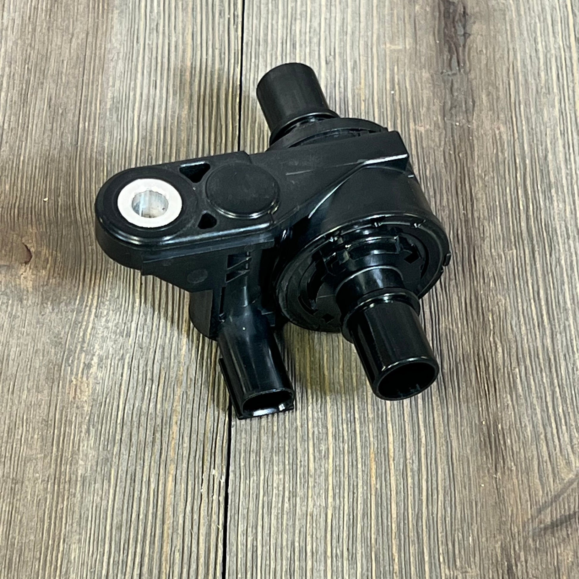 Black NOVAPARTS coolant water control valve for 2019-2023 Toyota Corolla and Lexus UX200 models, on wooden surface.