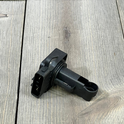 Black OYEAUTO Mass Air Flow Sensor for Toyota and Lexus, compatible with various models, shown on a wooden surface.