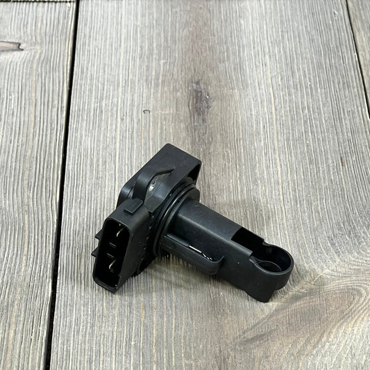 Black OYEAUTO Mass Air Flow Sensor for Toyota and Lexus, compatible with various models, shown on a wooden surface.