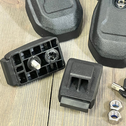 Black OEM hood latches with key for Jeep Wrangler JL JLU and Gladiator JT 2018-2024 displayed on a wooden surface.