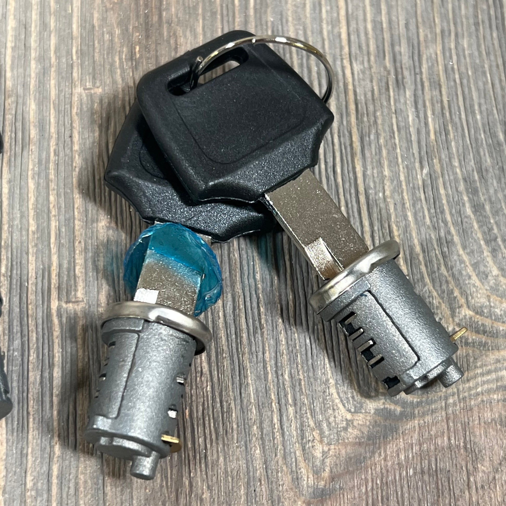 Durable metal lock cylinders and keys for Yakima car roof rack, featuring secure locking mechanism on wood surface.