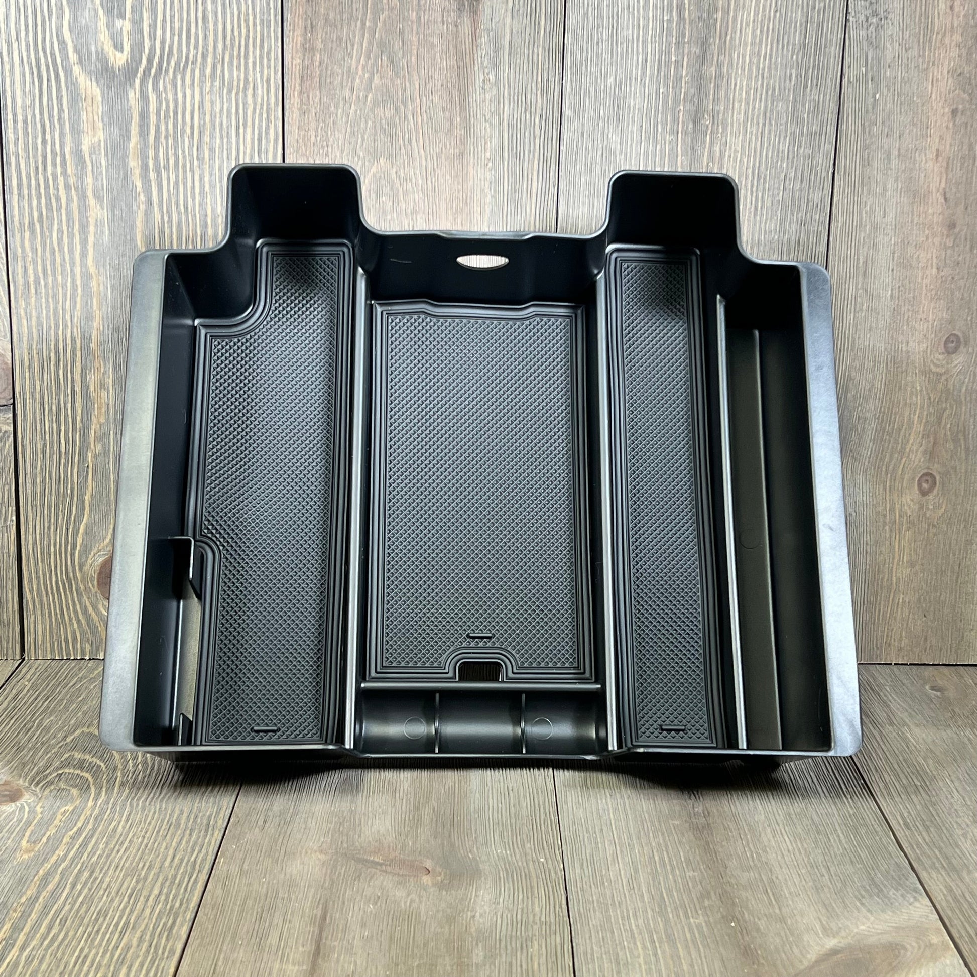 Black center console organizer compatible with Chevy Silverado and GMC Sierra, featuring multiple compartments for storage.