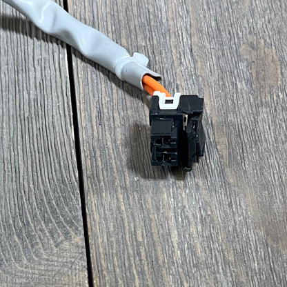 Close-up of the connector and wiring for the Yendse WH23X28418 Hotpoint GE washer drain pump motor on a wooden surface.